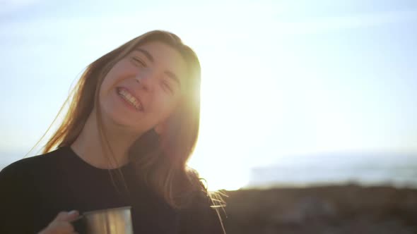 Closeup Cheerful Long Haired Girl Looking at Camera Holding Steel Cup with Hot Coffee on Nature