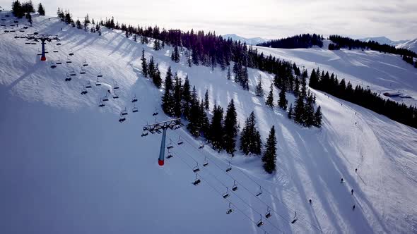 Aerial view of People Skiing and snowboarding on hill, Ski Resort. Drone flies over Skiers Skiing do