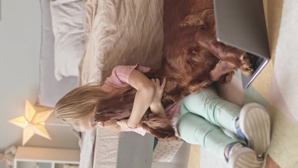 Girl with Dog Watching Video on Laptop