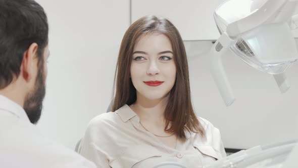 Charming Woman Checking Her Teeth in the Mirror at Dental Clinic