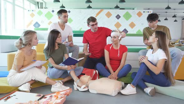 Confident Male Safety Instructor Teach Students To Bandage the Head in Case of Injury