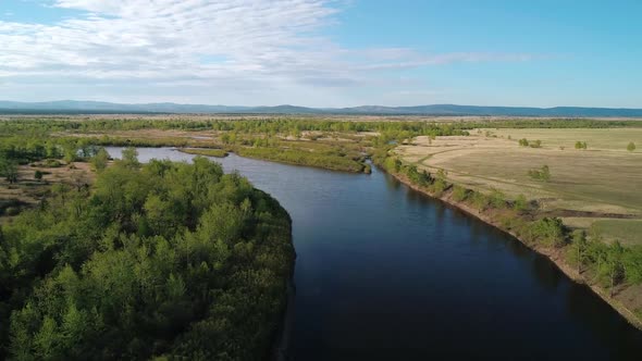 Aerial View of a River Flowing Through Rural Area with Meadows Rare Trees