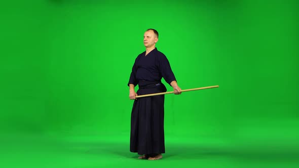 Masculine Kendo Warrior Practicing Martial Art with the Bamboo Bokken on Green Screen.