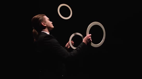 Camera Rotates Around Showman Trowel Juggling White Rings