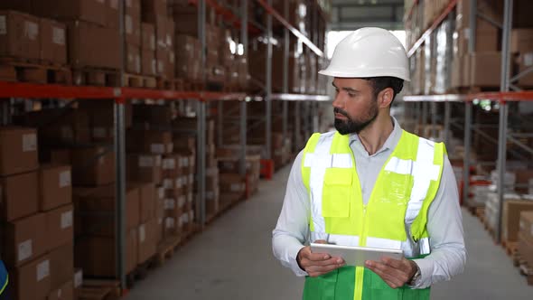 Focused Man Worker Doing Stocktaking in Warehouse