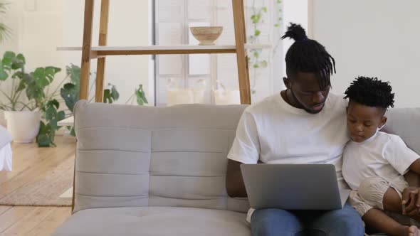 Father and son using technology together at home