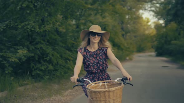 Woman Cyclist Riding On Bicycle In City Park. Woman In Hat Enjoying Summer. Bike On Countryside.