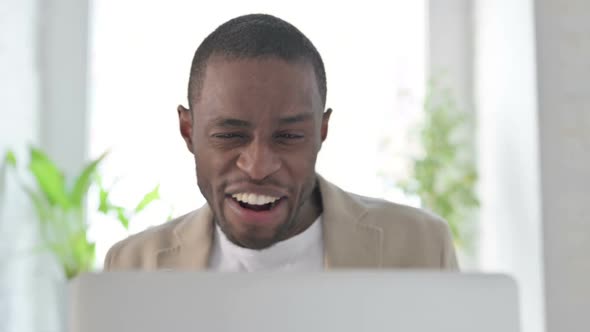 Close Up of African Man Celebrating Success on Laptop