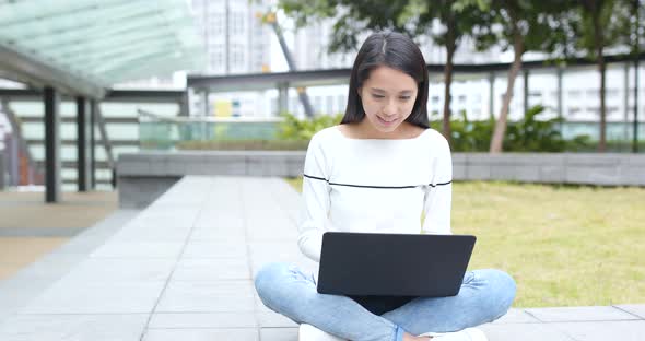 Young Woman using on laptop computer at outdoor