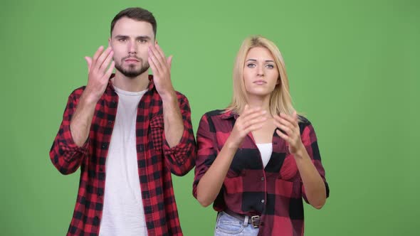 Young Couple Covering Eyes Together As Three Wise Monkeys Concept