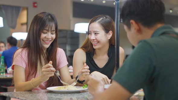 Asian young attractive beautiful woman having lunch with friends in a restaurant in shopping mall.