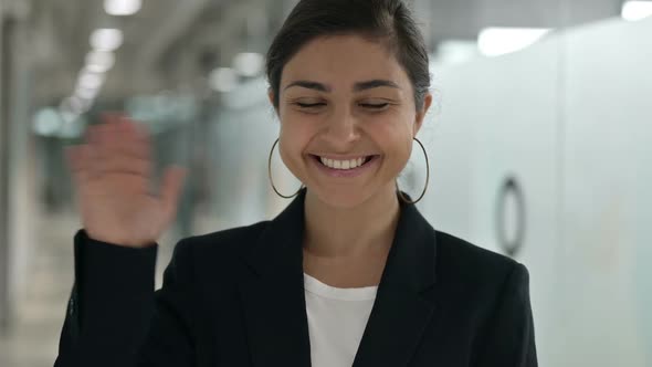 Portrait of Cheerful Young Indian Businesswoman Waving at the Camera