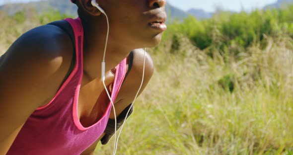 Female athlete relaxing after jogging in the forest