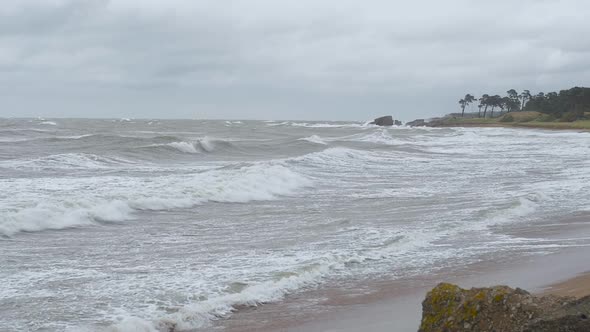 Waves breaking against Baltic sea coastline at Liepaja, stormy overcast autumn day, slow motion medi