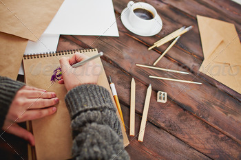 g and artist hands with pen over notepad