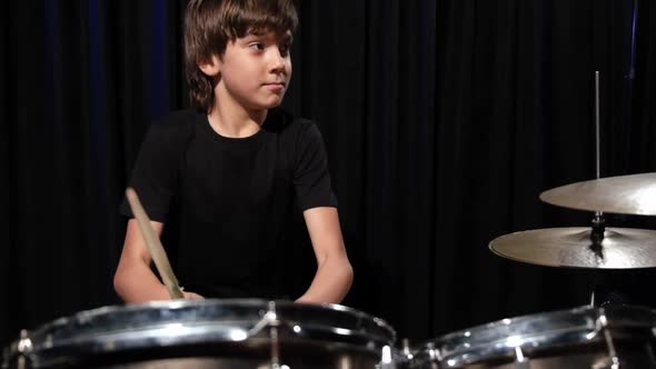 A Boy Plays Drums in a Recording Studio