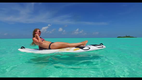 Girls sunbathing on tranquil coast beach vacation by blue lagoon with clean sand background of the M