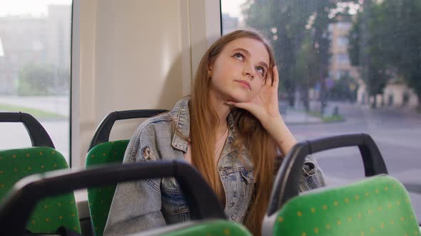 Tired Depressed Young Woman Sitting Alone Near the Public Bus Transport Window After Hard Work Day