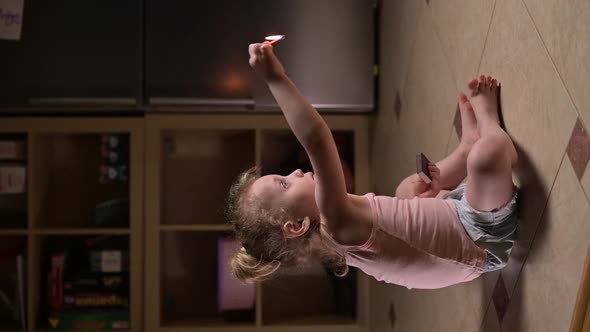 child enthusiastically lights a match. girl playing with matches at home alone