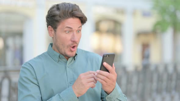 Outdoor Man having Loss while Browsing on Smartphone