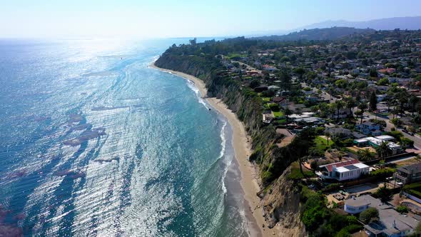 Santa Barbara beach and cliff drone panning up.