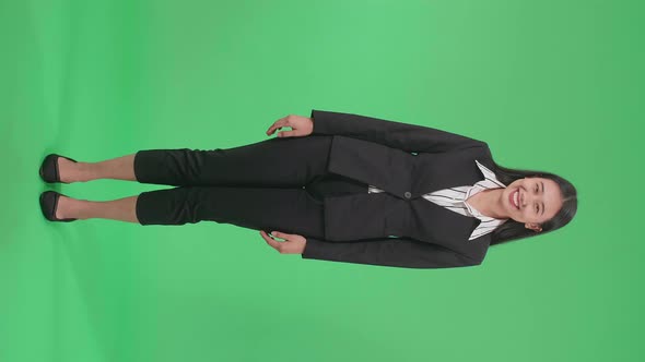 Full Body Of An Asian Business Woman Warmly Smiling On Green Screen Background In The Studio