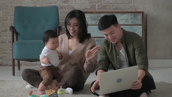 Young parents with an innocent baby in their arms communicate via video link