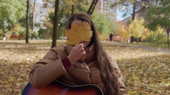 Young Romantic Talented Beautiful Girl Woman Composer Musician with Long Hair Plays Guitar Sings