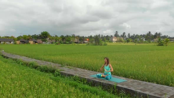 Slowmotion Aerial Shot of a Young Woman Doing Meditation for Muladhara Chakra in a Balinese Way