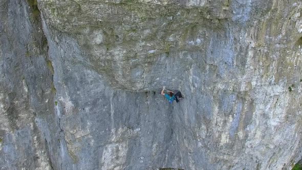 Aerial view of a man rock climbing up a mountain