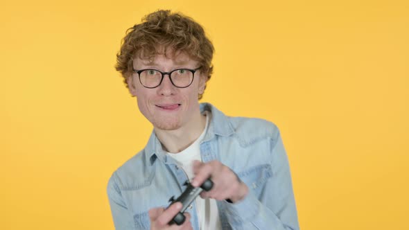 Redhead Young Man Playing Video Game, Yellow Background 