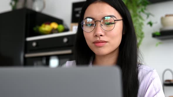 Pretty Positive Smart Asian Brunette Girl with Glasses Designer Freelancer or Student Sits at Home