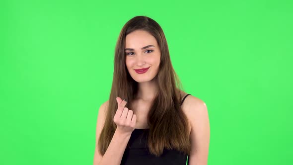 Cute Girl Smiles and Showing Heart with Fingers Then Blowing Kiss. Green Screen