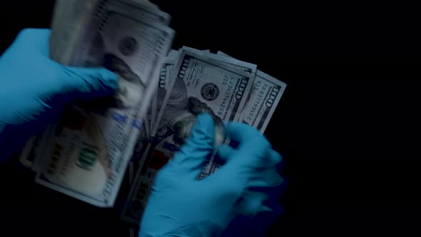 4K 24fps hands counting a fat stack of one hundred dollar bills onto a black background ideal for sc