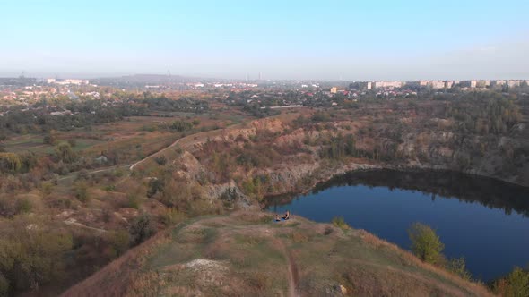 Aerial Drone View of Slender Young Mother Do Yoga Exercises with Child Daughter on High Hill By Lake