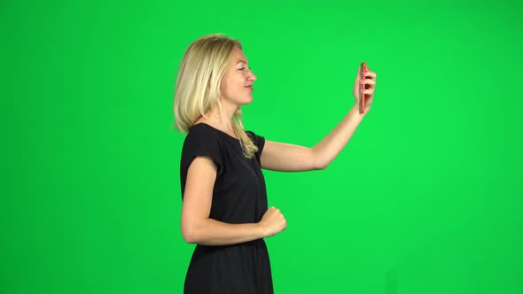 Woman Tourist Goes and Takes a Selfie, Then Looks Through the Photos on the Smartphone. Chroma Key