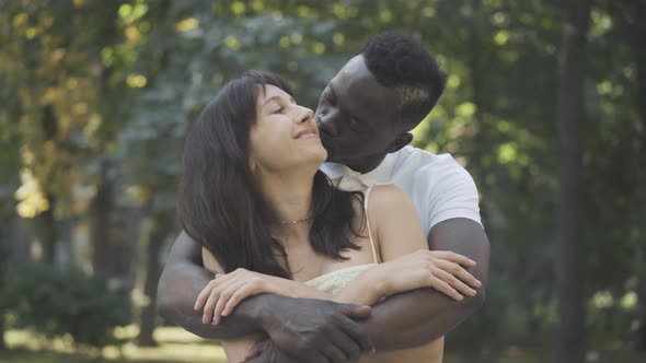 Portrait of Happy Hugging Couple Dating Outdoors. Young Loving Caucasian Woman and African American