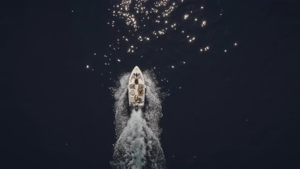 Aerial view of small speed boat with trailing wake on sea.