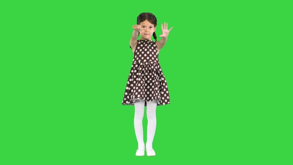 Beautiful Young Girl Wearing Polkadot Dress Showing Her Age with Fingers and Pronouncing It To the