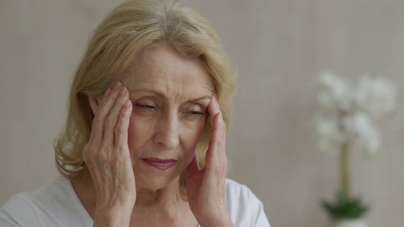 An Elderly Woman Has Headaches She Touches Her Head with Her Hands Reports Symptoms of Dizziness