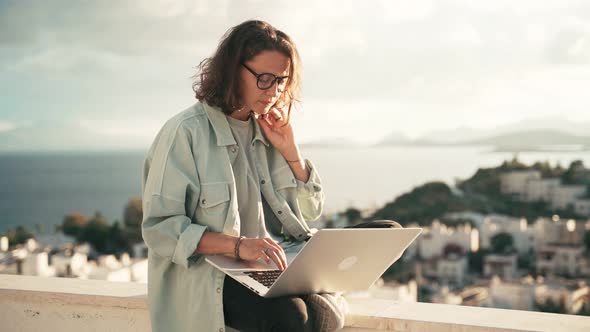 Young Woman Freelancer Working with Her Laptop on the Roof Terrace.