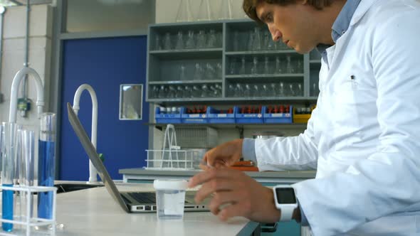 Scientist checking prescription and using laptop