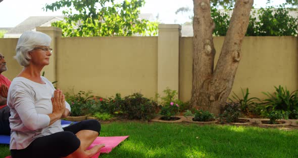 Senior friends performing yoga in garden 4k