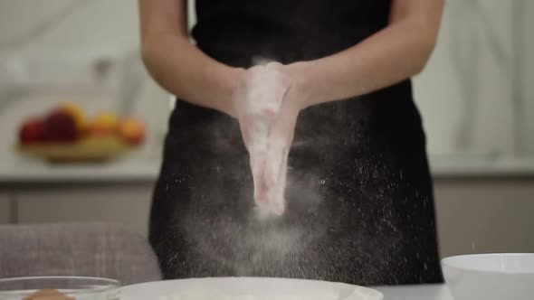 Professional Female Cook Claps Her Hands and Powder Flies