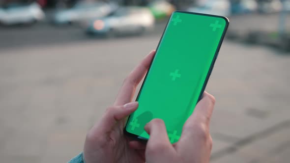 Lviv Ukraine May 6 2022 Hands Texting Touch Holding a Mobile Telephone with a Vertical Green Screen