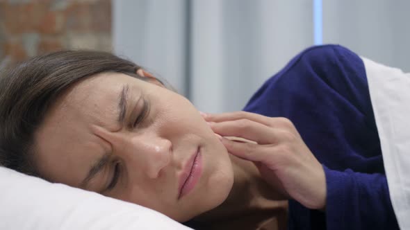 Hispanic Woman Lying in Bed Suffering Toothache, Teeth Pain
