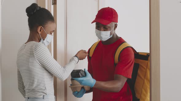 Young African American Lady Customer Paying for Takeout Coffee Delivery with Smartwatch and Taking