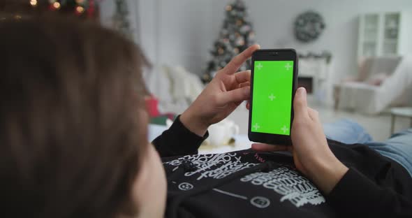 Boy Uses Phone Green Background Christmas Atmosphere