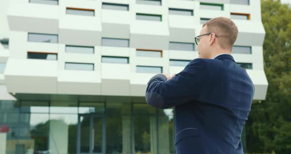 The Businessman Is Going and Talking Emotionally on the Phone and Waving His Hand