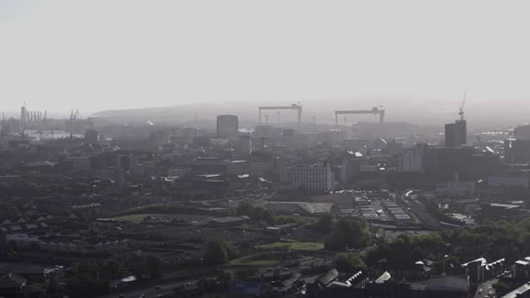 Aerial flyover of west Belfast from the countryside looking towards the city centre or center